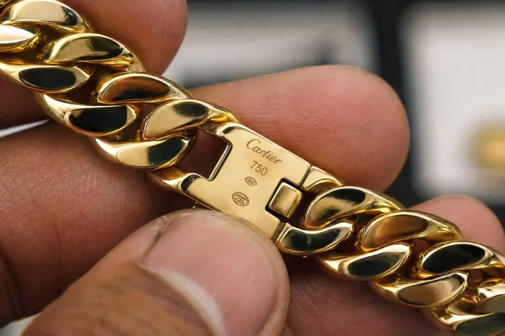 Corrente de ouro 18K estilo Cartier sendo examinada por um especialista em avaliação.